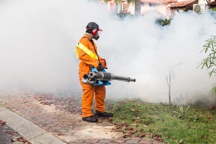 Worker spraying mosquito control - Caribbean National Weekly News