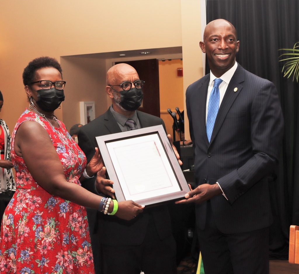 Basil watson accepting proclamation from Wayne Messam