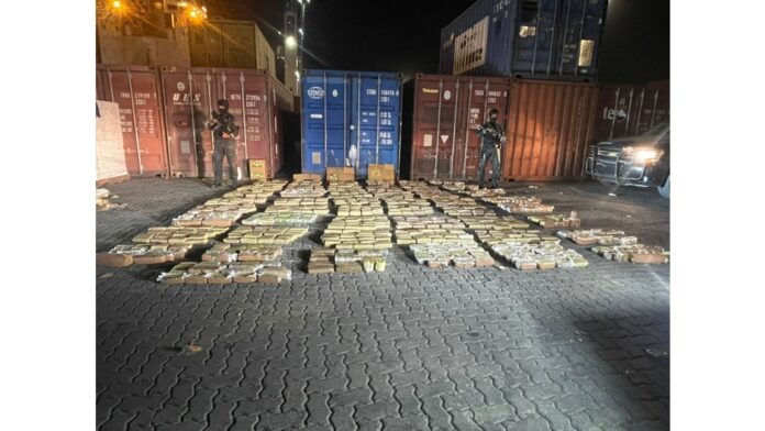 Police stand guard over packets of marijuana seized from a shipping container in the Dominican Republic.